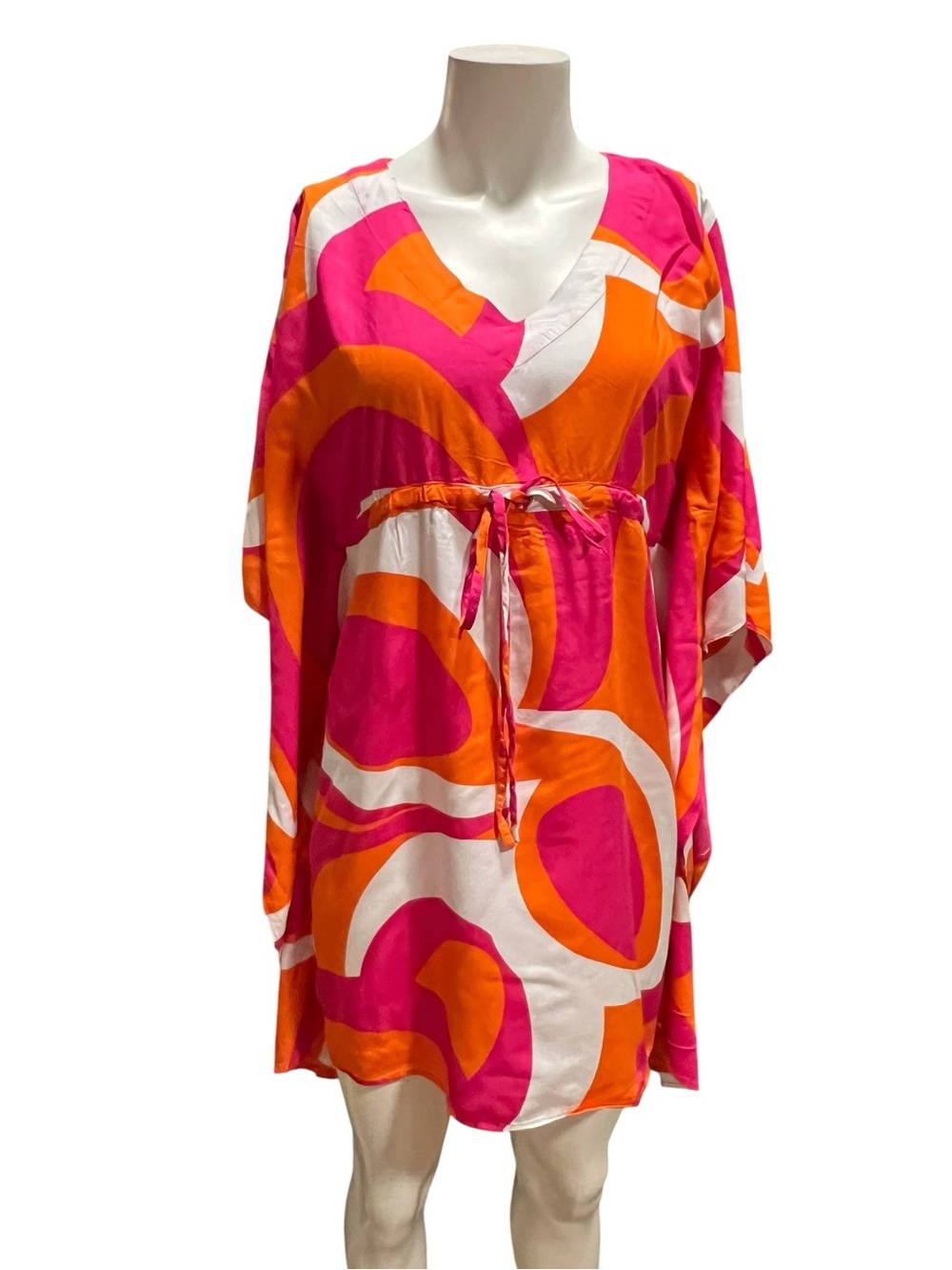 Escapada brand cover-up features a pink and orange kaleidoscope pattern with a w